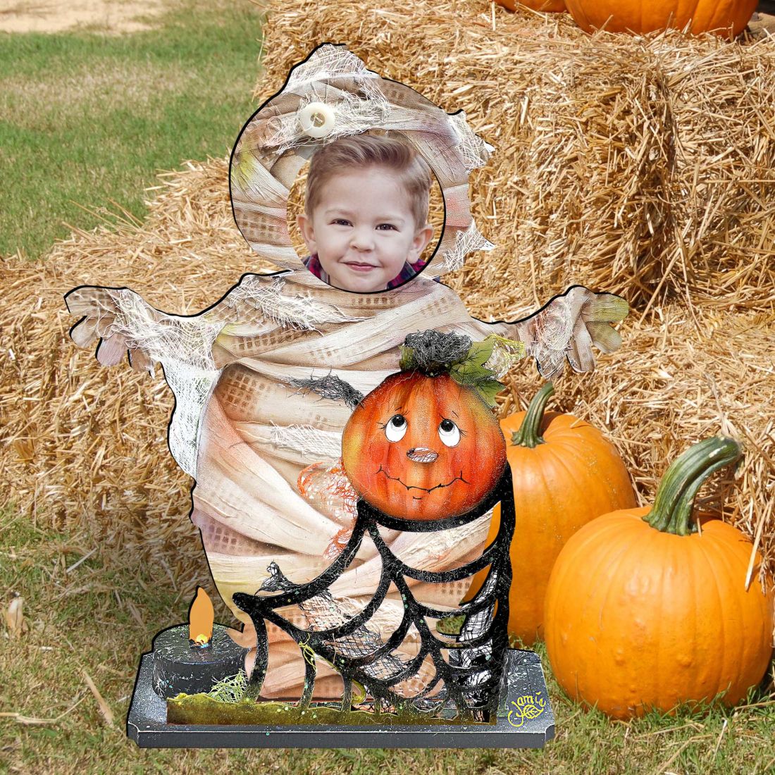 Halloween yard decor figure with mummy-clad child, jack-o’-lantern, and candle-lit spiderweb base