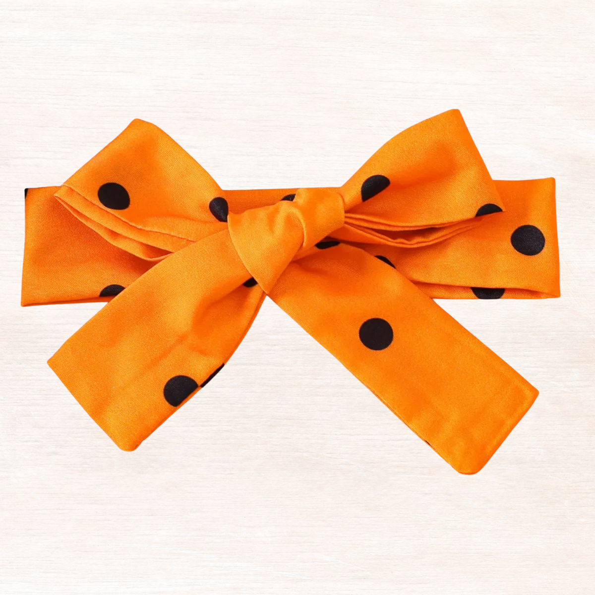 Polka-dot headband with large orange bow