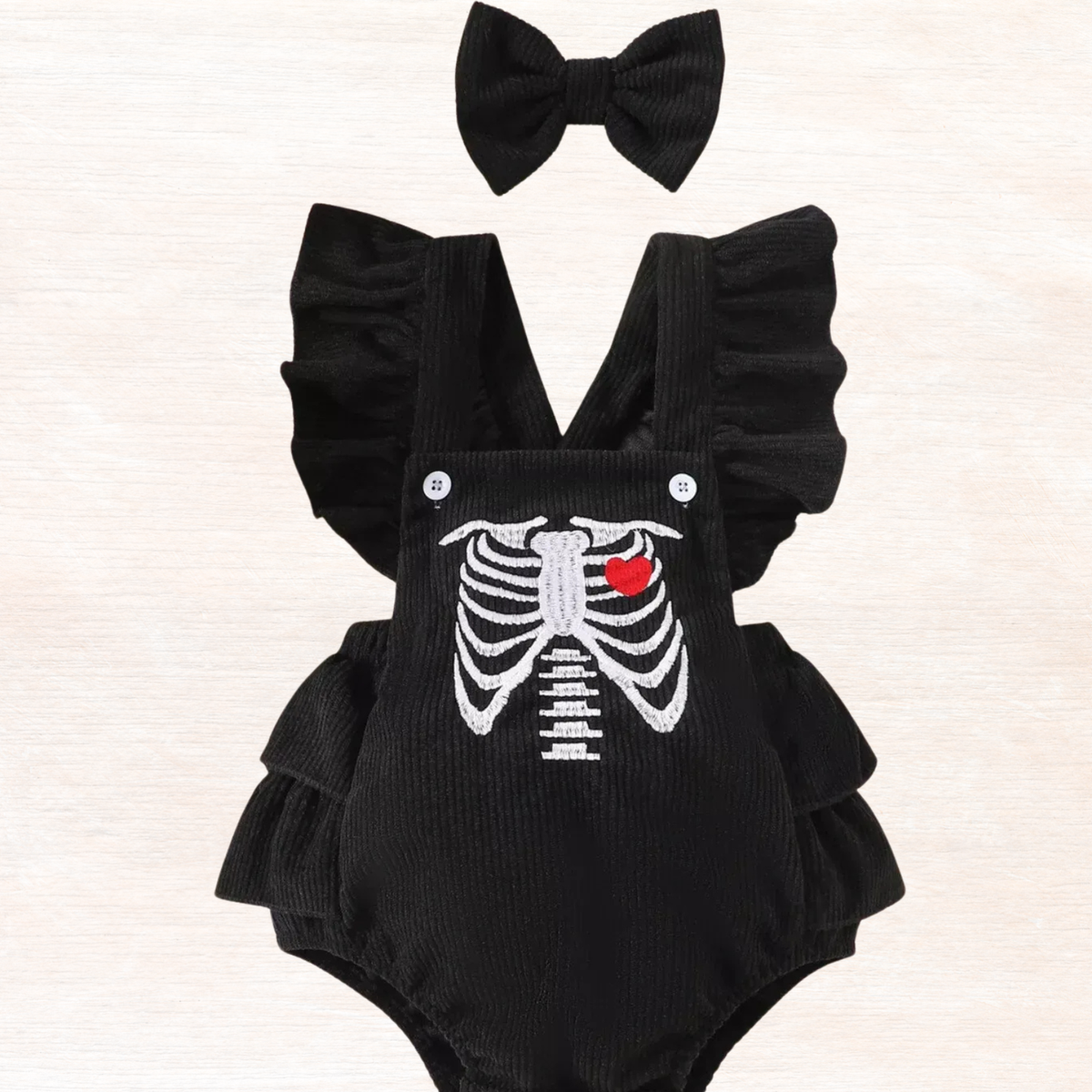 Black ruffle bodysuit with skeleton ribs graphic and red heart, bow headband