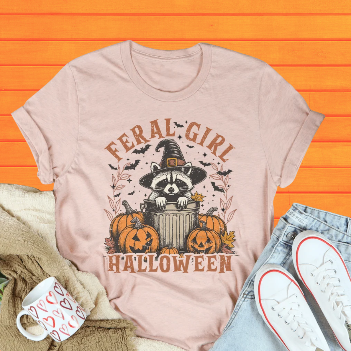 Heather prism peach Halloween graphic tee with raccoon in witch hat and pumpkin patch