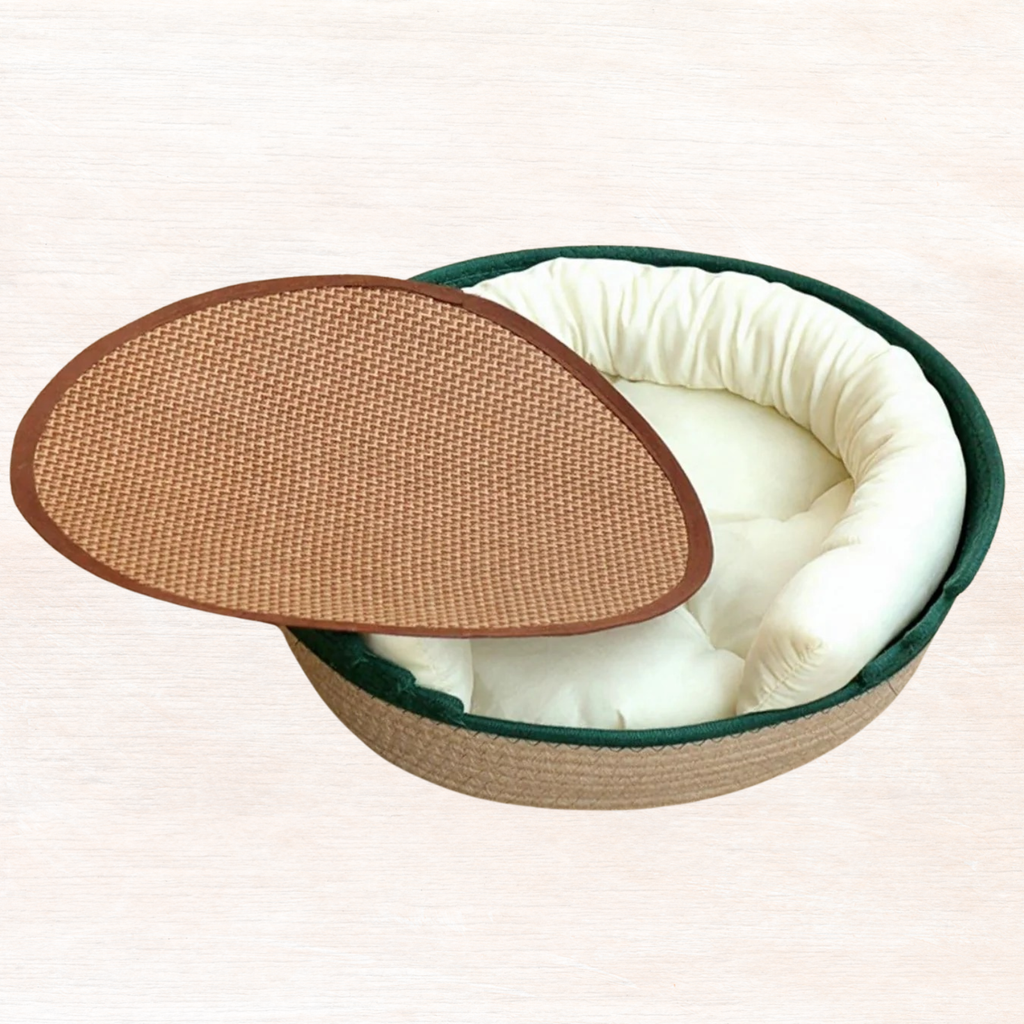 Woven pet nest with dark green rim, brown woven top, cream cushion interior.
