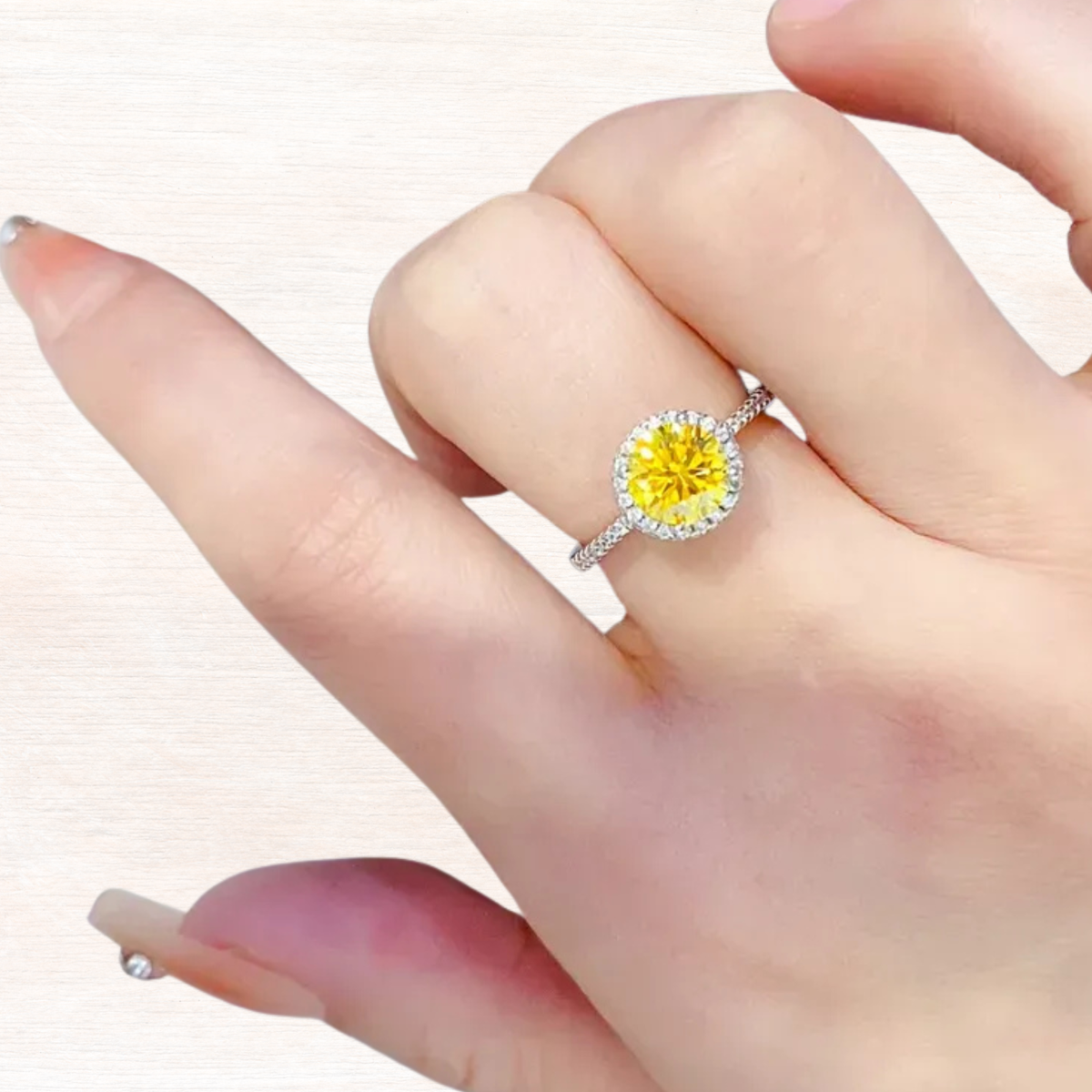 Sterling silver ring with yellow moissanite halo on a hand