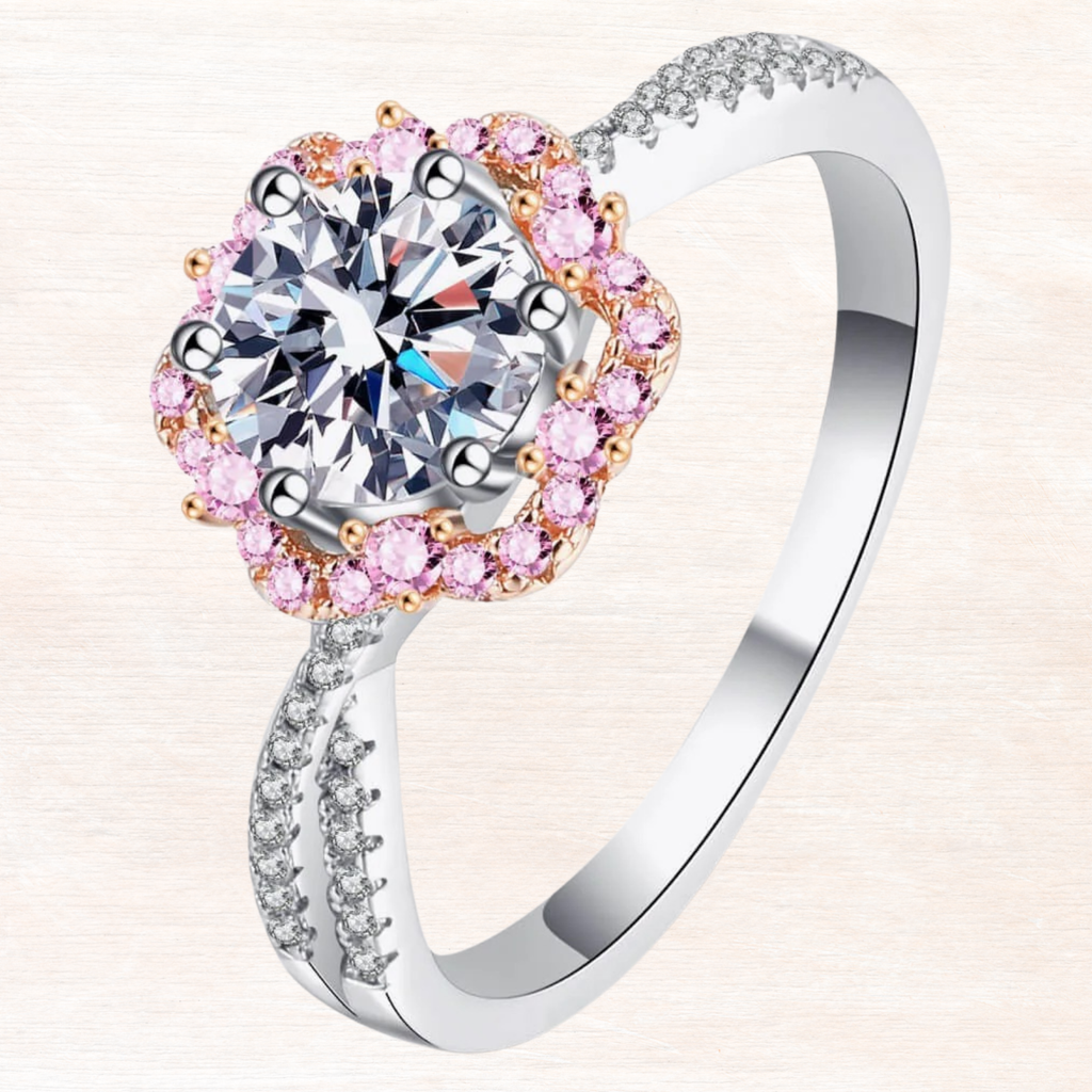 Silver ring front view with round center stone, pink side halo and gold-toned prongs