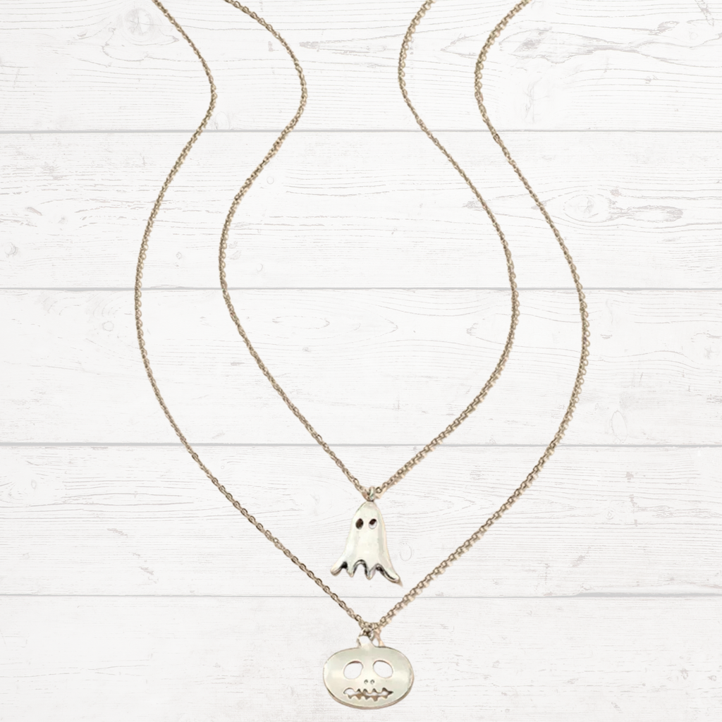 Silver pendant necklace with ghost and jack-o-lantern charms on linked chains.
