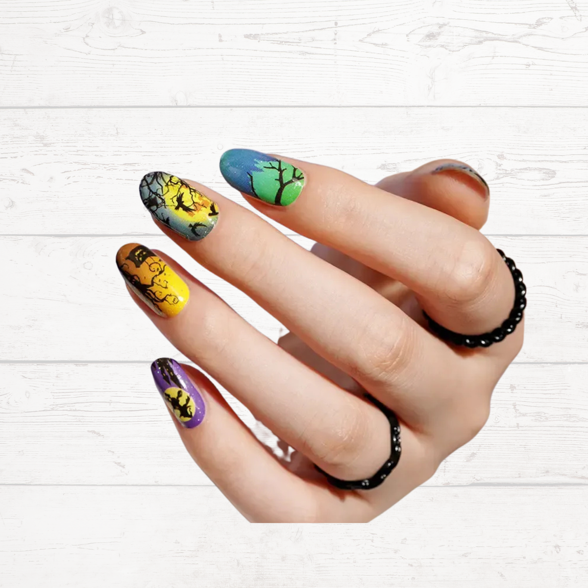 Halloween patterned press-on nails in close-up with black, yellow, blue, and green