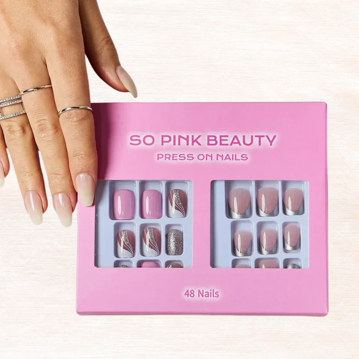 Pressed nail sets in pink box, nude and silver styles, shown with nails on hand