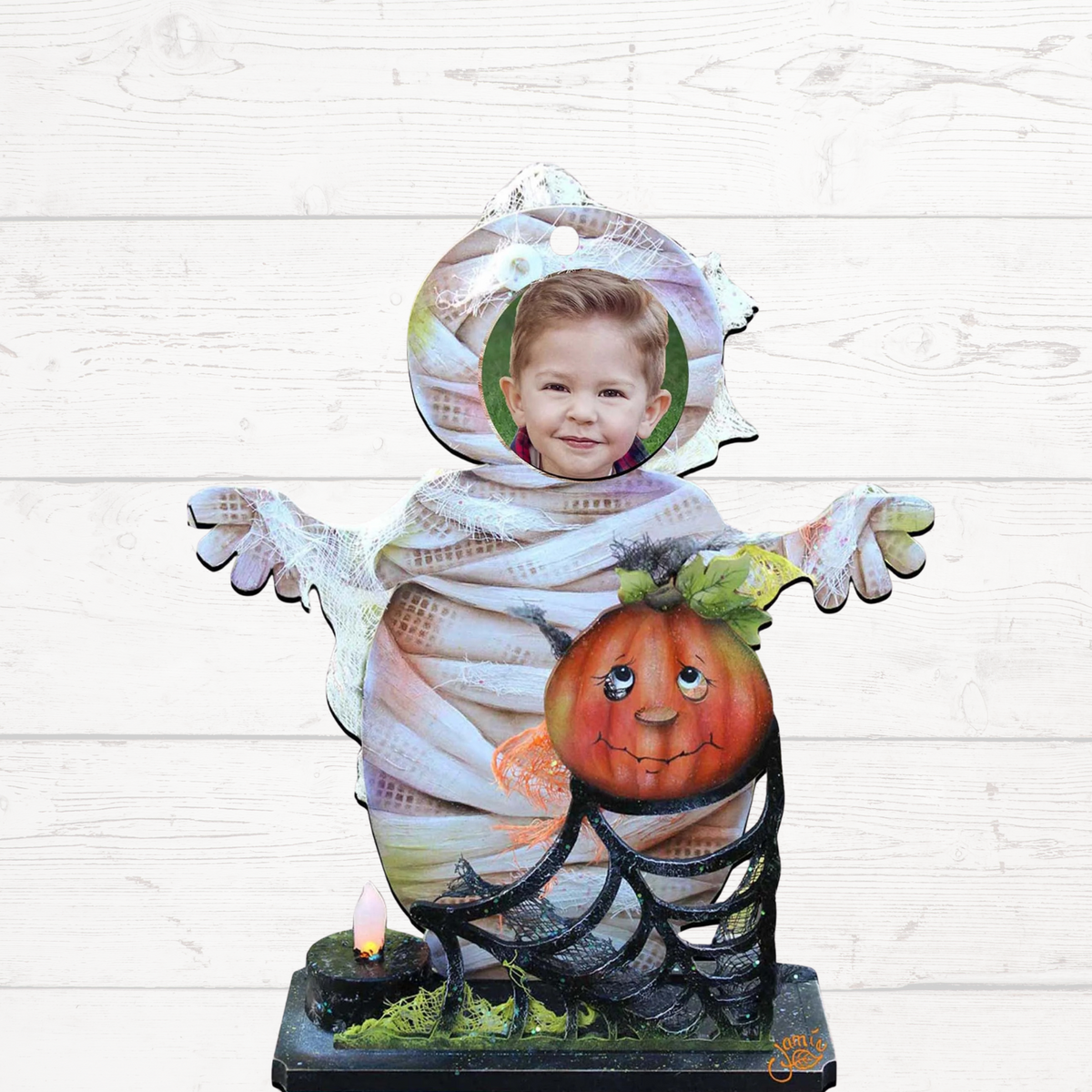 Halloween yard decor figure: smiling child in mummy costume holding a jack-o’-lantern