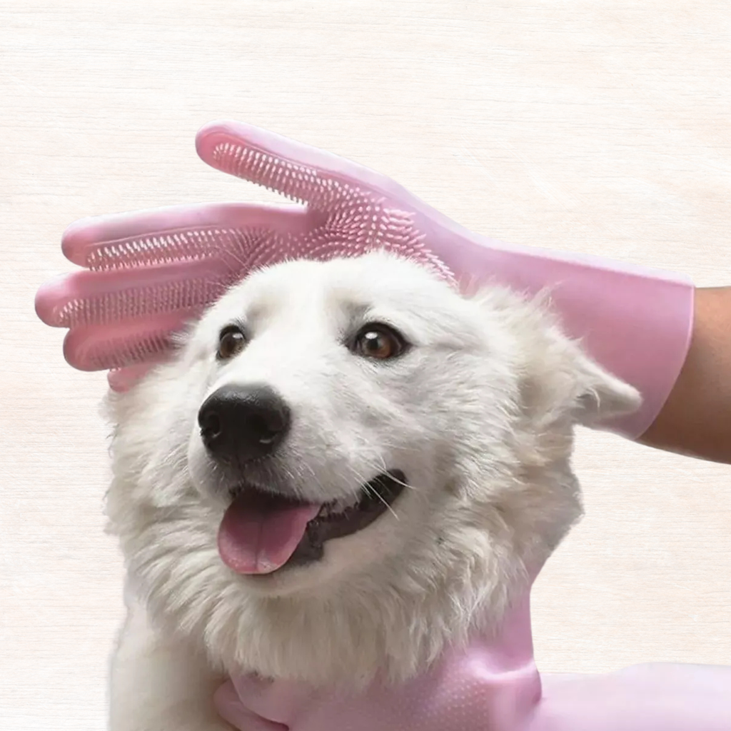Pink pet grooming glove with raised bristles, shown on a dog