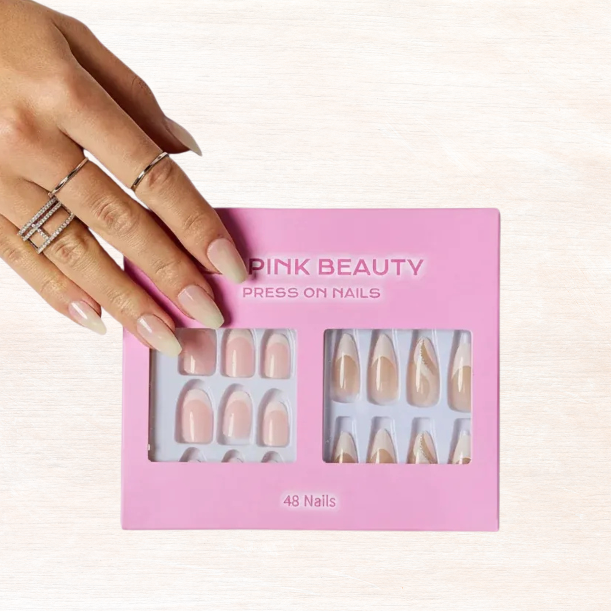 Press-on nails in pink box with nude tips and gold details, 48 nails