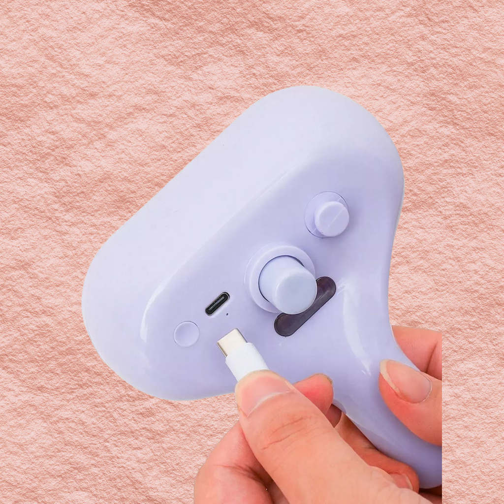 Lilac pet hair remover comb with two circular buttons and nozzle port.