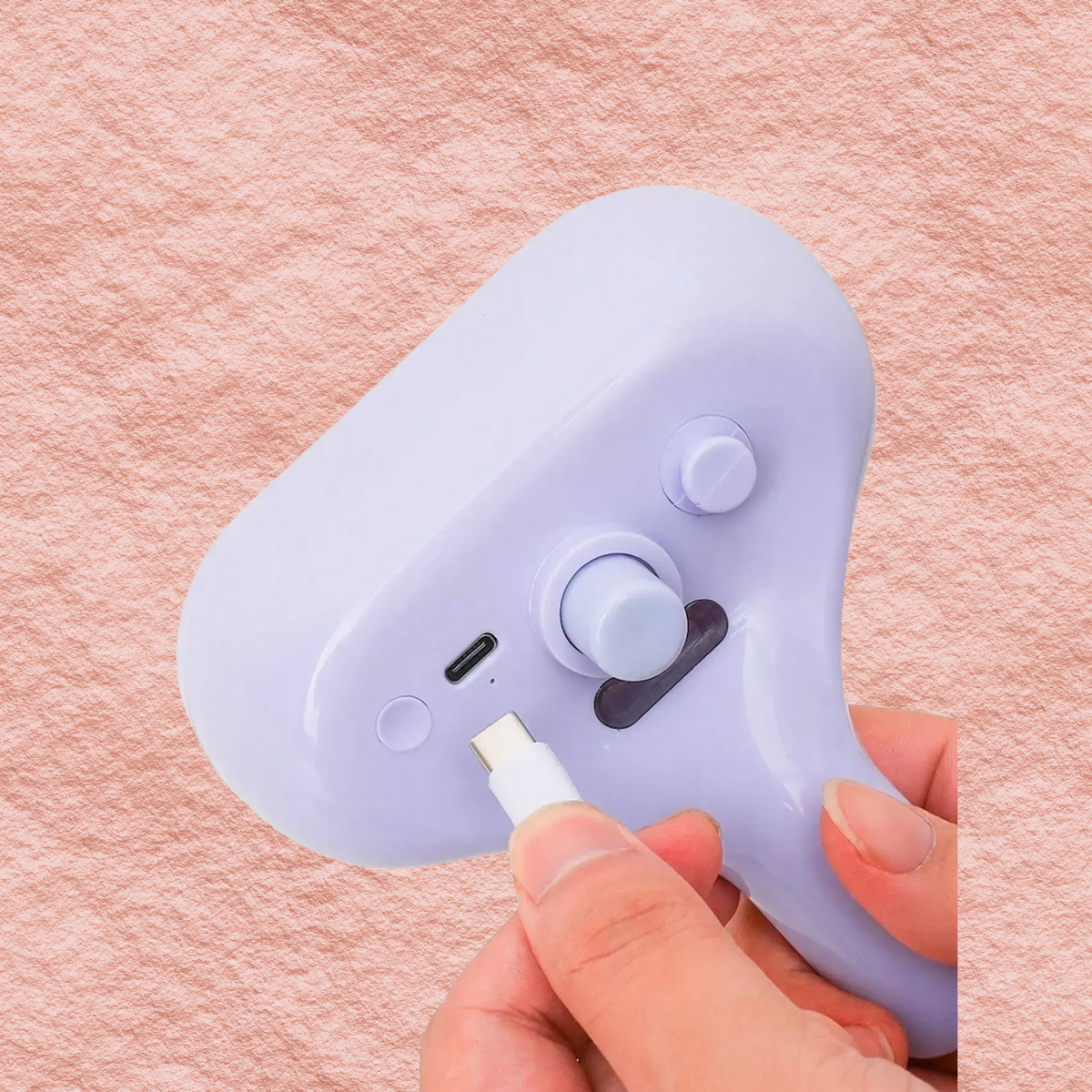 Lilac pet hair remover comb with two circular buttons and nozzle port.