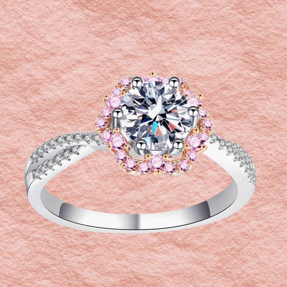 Silver ring close-up: round center stone in pink halo with crisscross-style band