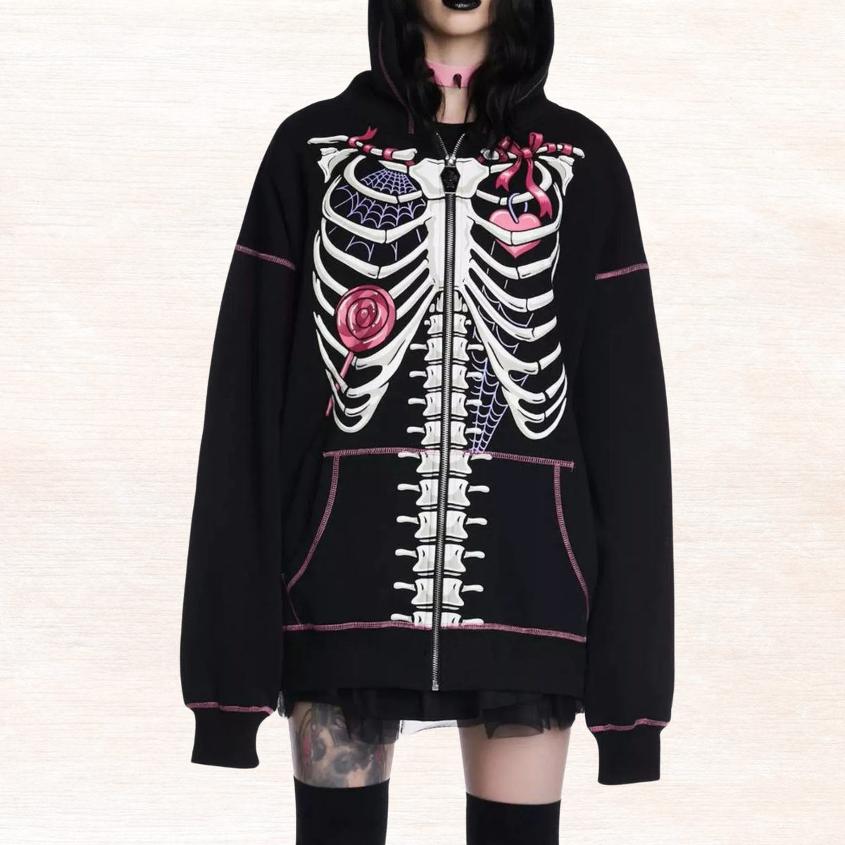 Black zip hoodie with full skeleton graphic, pink trim, and long sleeves.