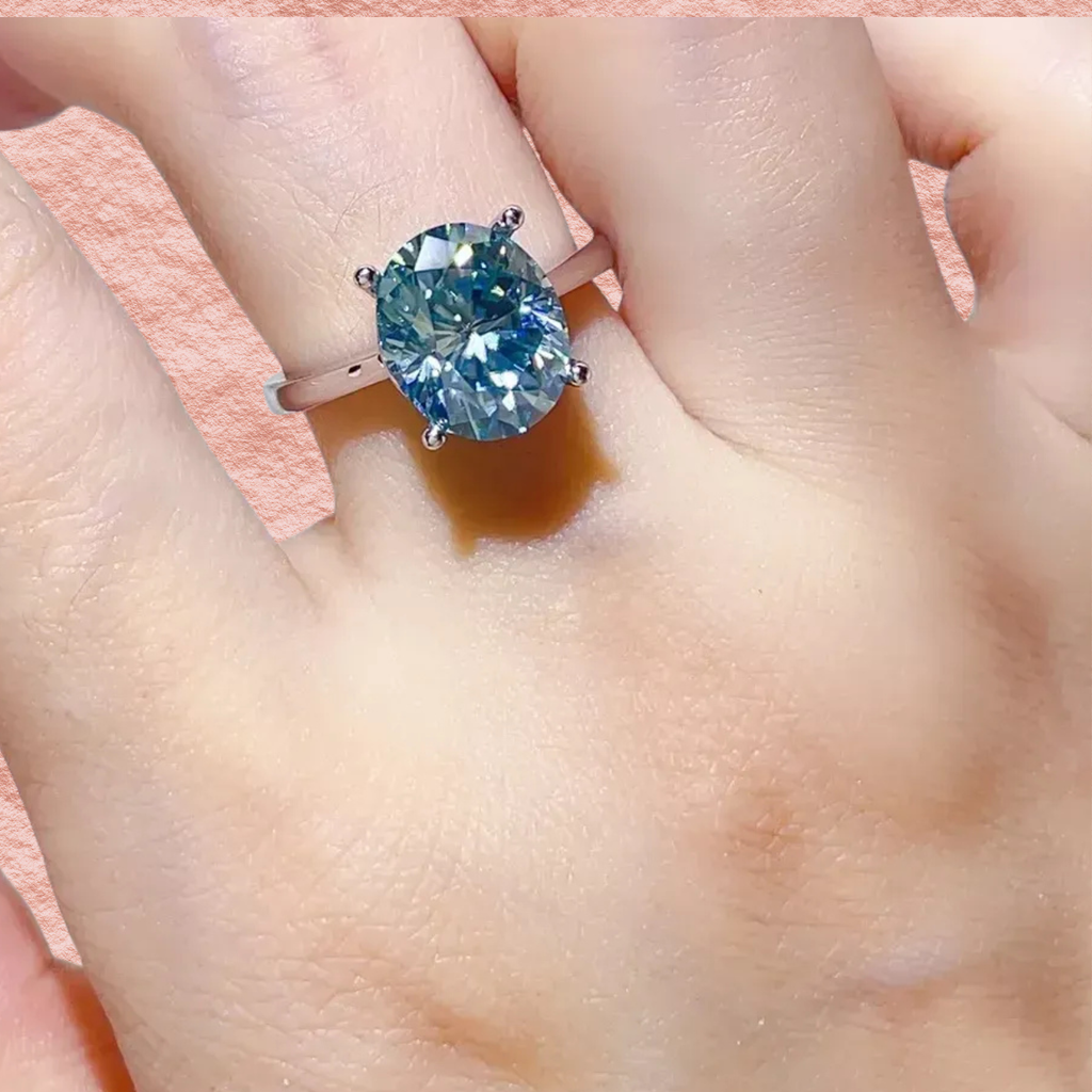 Sterling silver ring featuring blue moissanite oval center stone and side prongs