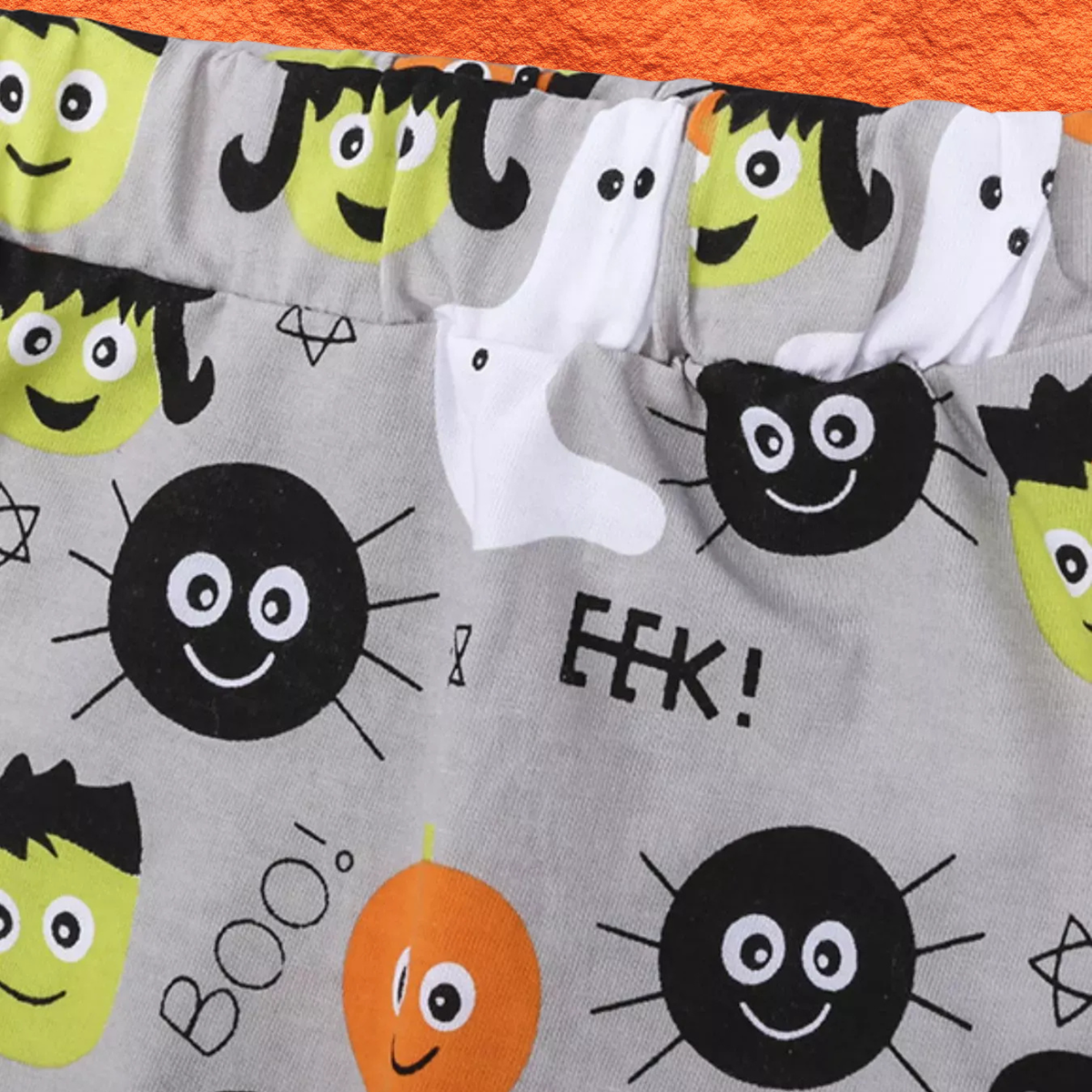 Gray pajama pants with monster face pattern and starburst spider graphic
