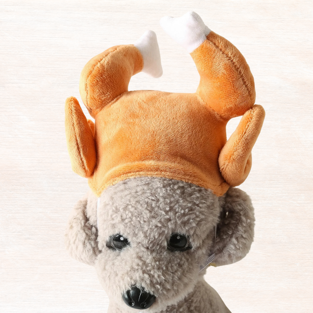 Plush orange turkey leg pet headwear with white top pads and grey animal face