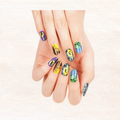 Halloween nail set on hand showing multiple patterned nails in yellow, blue, and purple