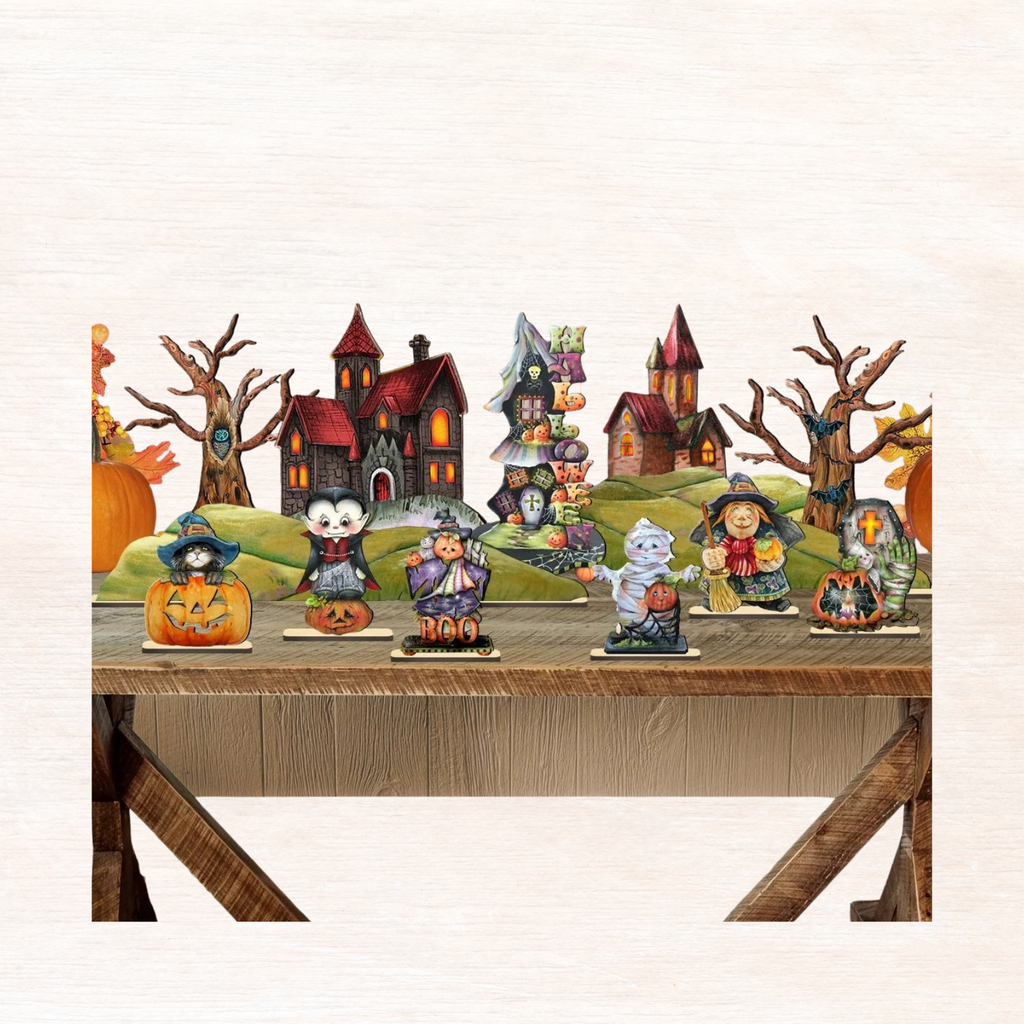 Halloween village figurine set arranged on wooden shelf with haunted houses, pumpkins, and cross.
