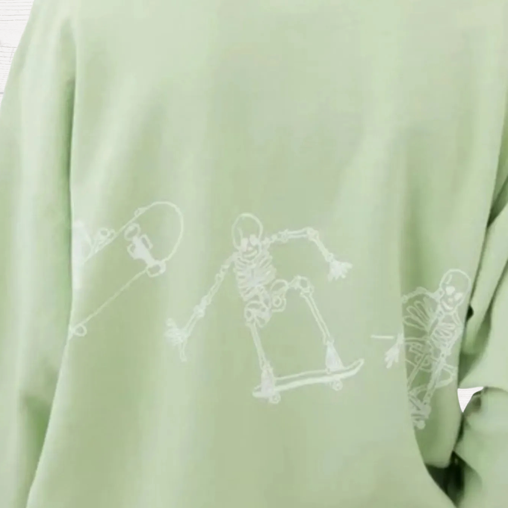 Light green oversized sweatshirt with faint white skeleton skateboard graphic