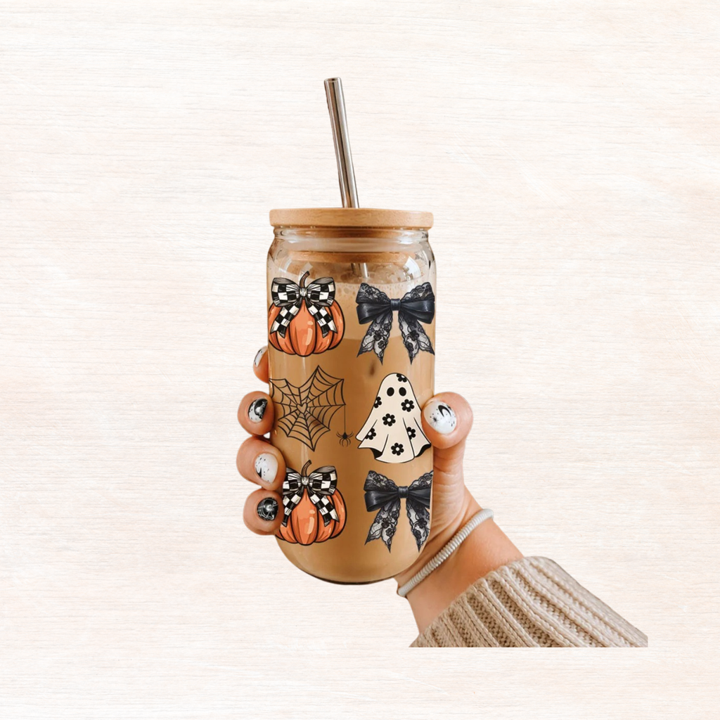 Hand holding a 20oz Halloween drink jar with straw, wooden lid, pumpkins and bats design