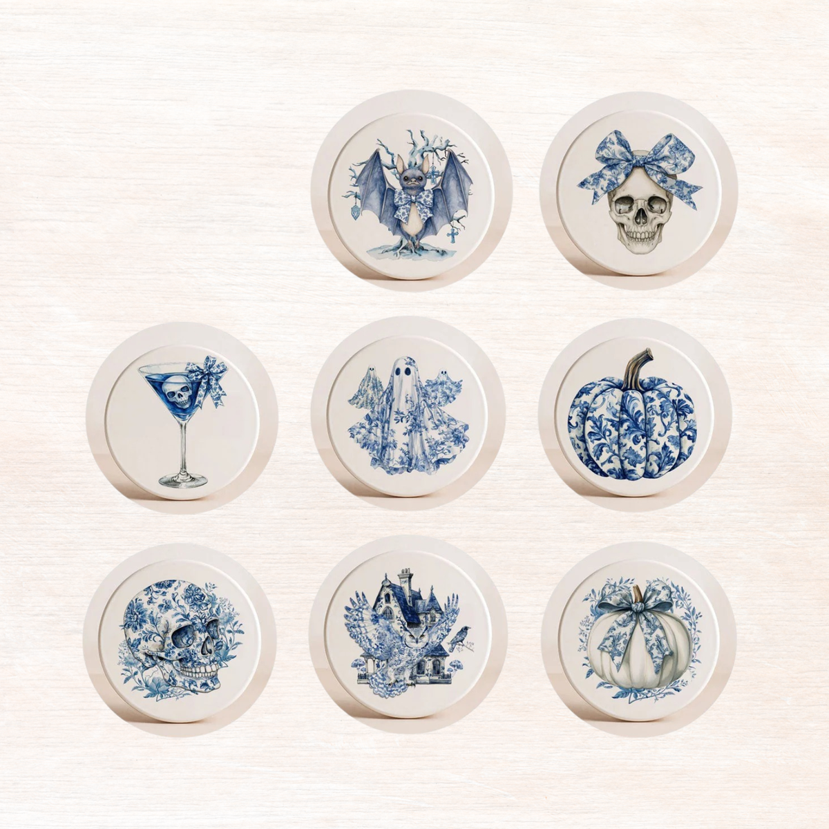 Assorted blue-and-white Halloween coasters in round tiles, with owl, skull, bat, and pumpkin art.