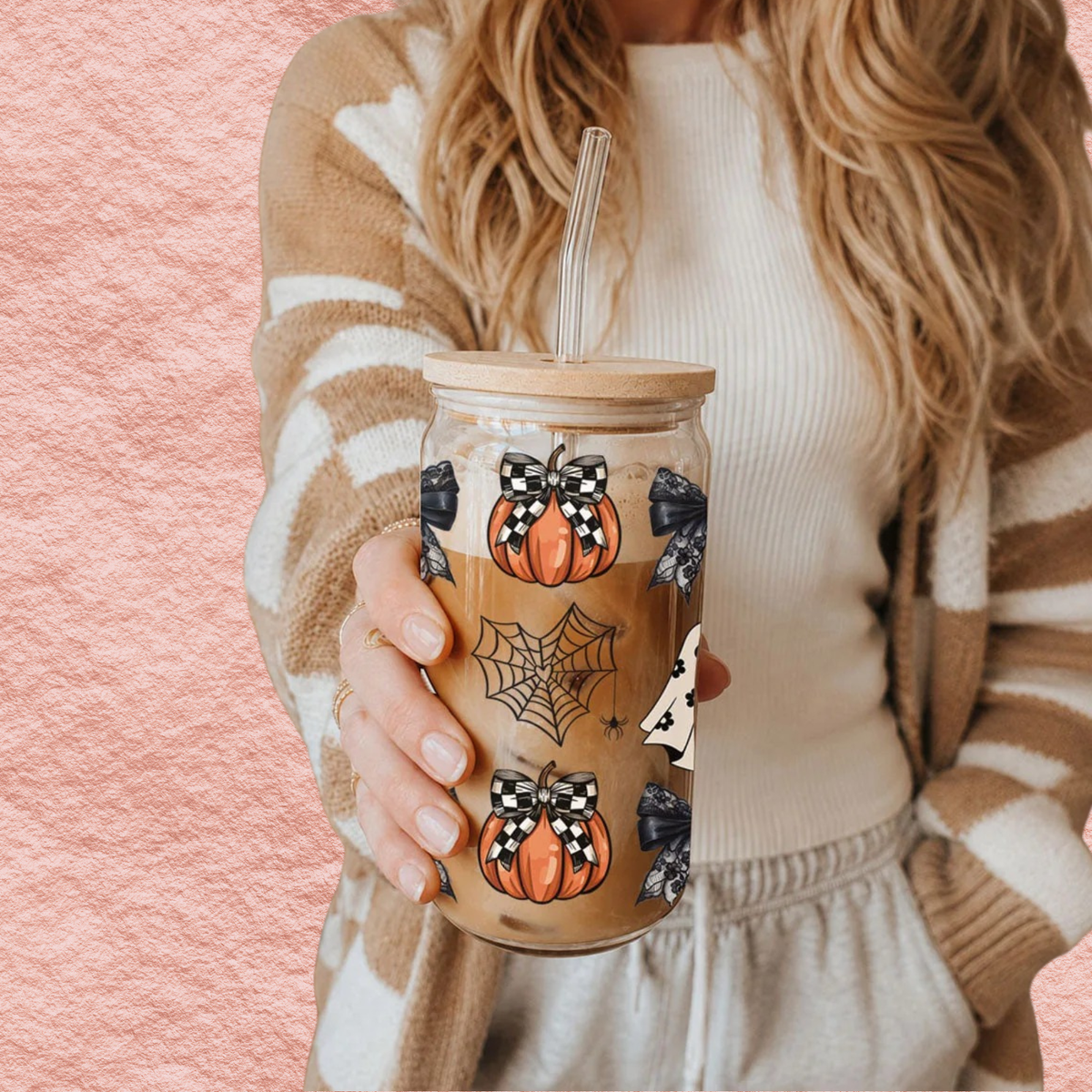 Woman holding a 20oz Halloween drink jar with straw, wooden lid, pumpkins and spiderweb print