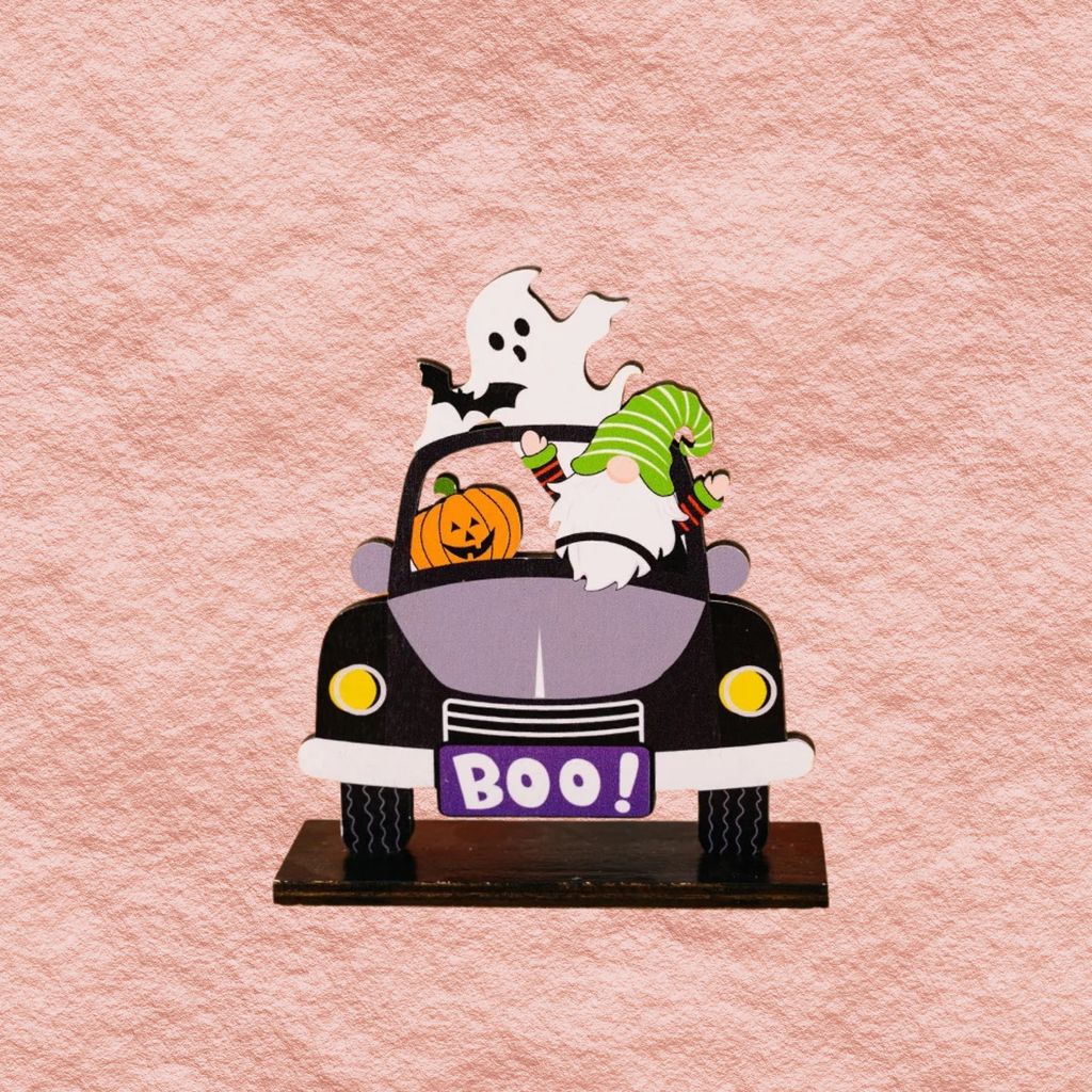 Close-up car-shaped Halloween ornament with ghost, pumpkins, and 'BOO!' front sign
