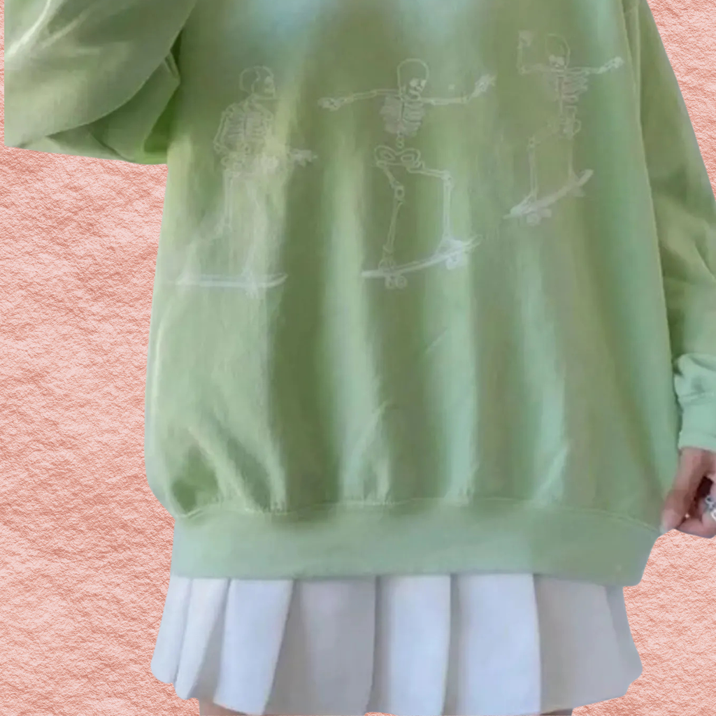 Pale green oversized sweatshirt with white skeleton skateboard graphic on front