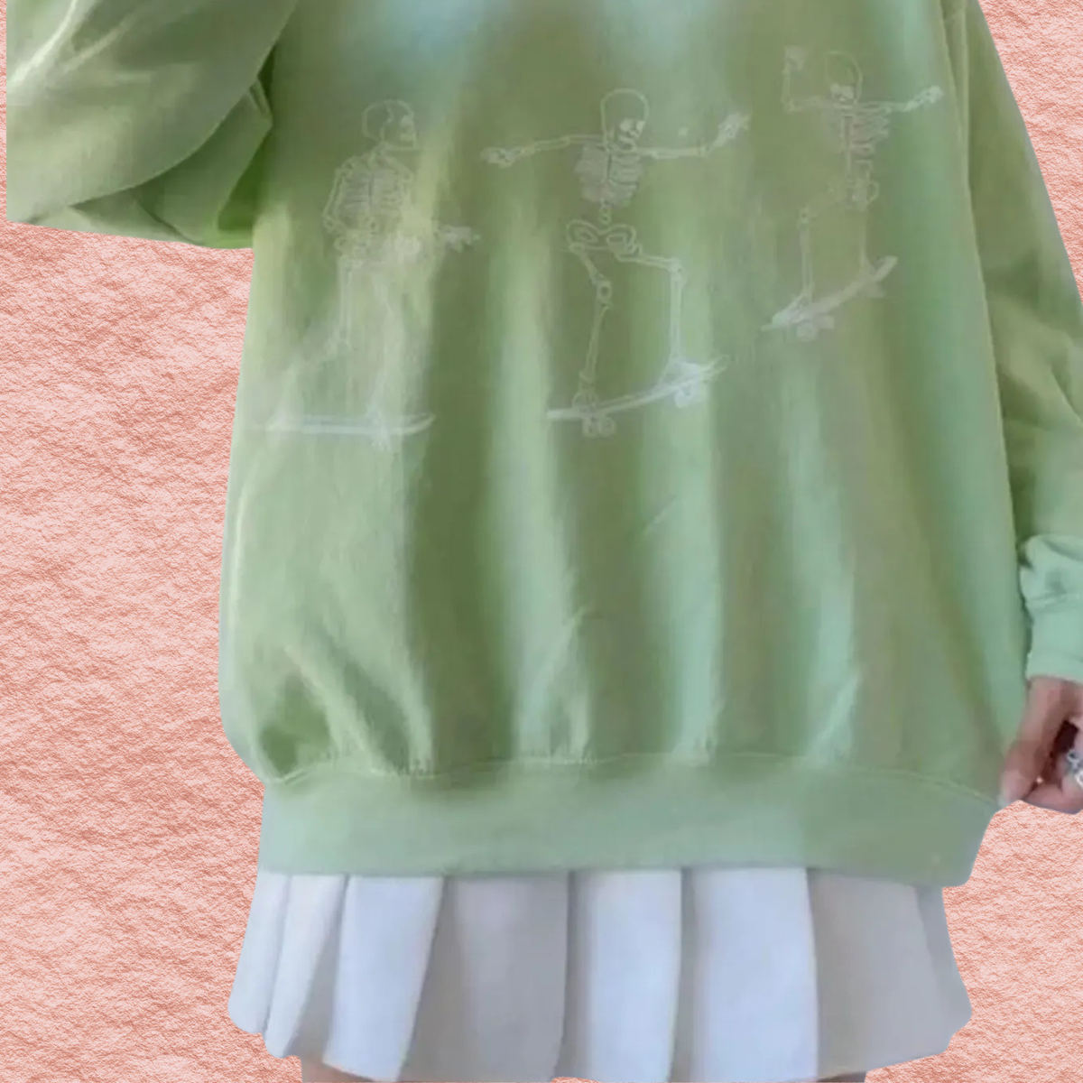 Pale green oversized sweatshirt with white skeleton skateboard graphic on front