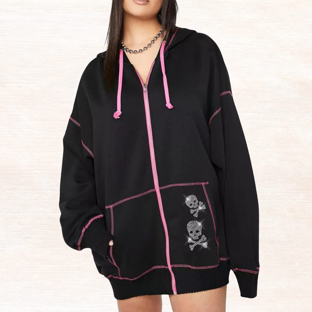 Black zip-up hoodie with pink drawstrings and embroidered skull patch pocket.