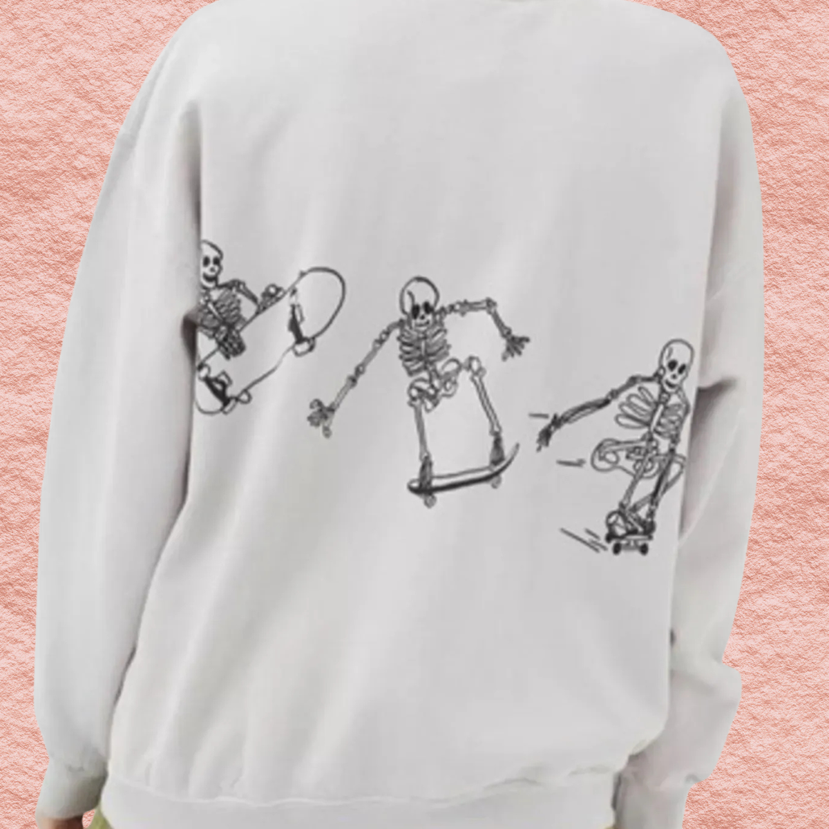White oversized sweatshirt with black skeleton skateboard graphic across back