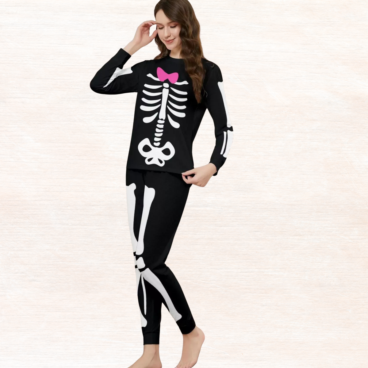 Black skeleton pajama set with long sleeves, pink bow chest graphic, and long pants