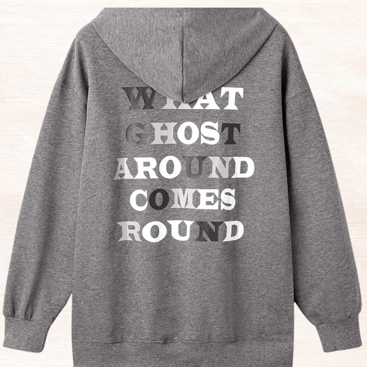 Dark gray oversized hoodie back with large 'WHAT GHOST AROUND COMES ROUND' text