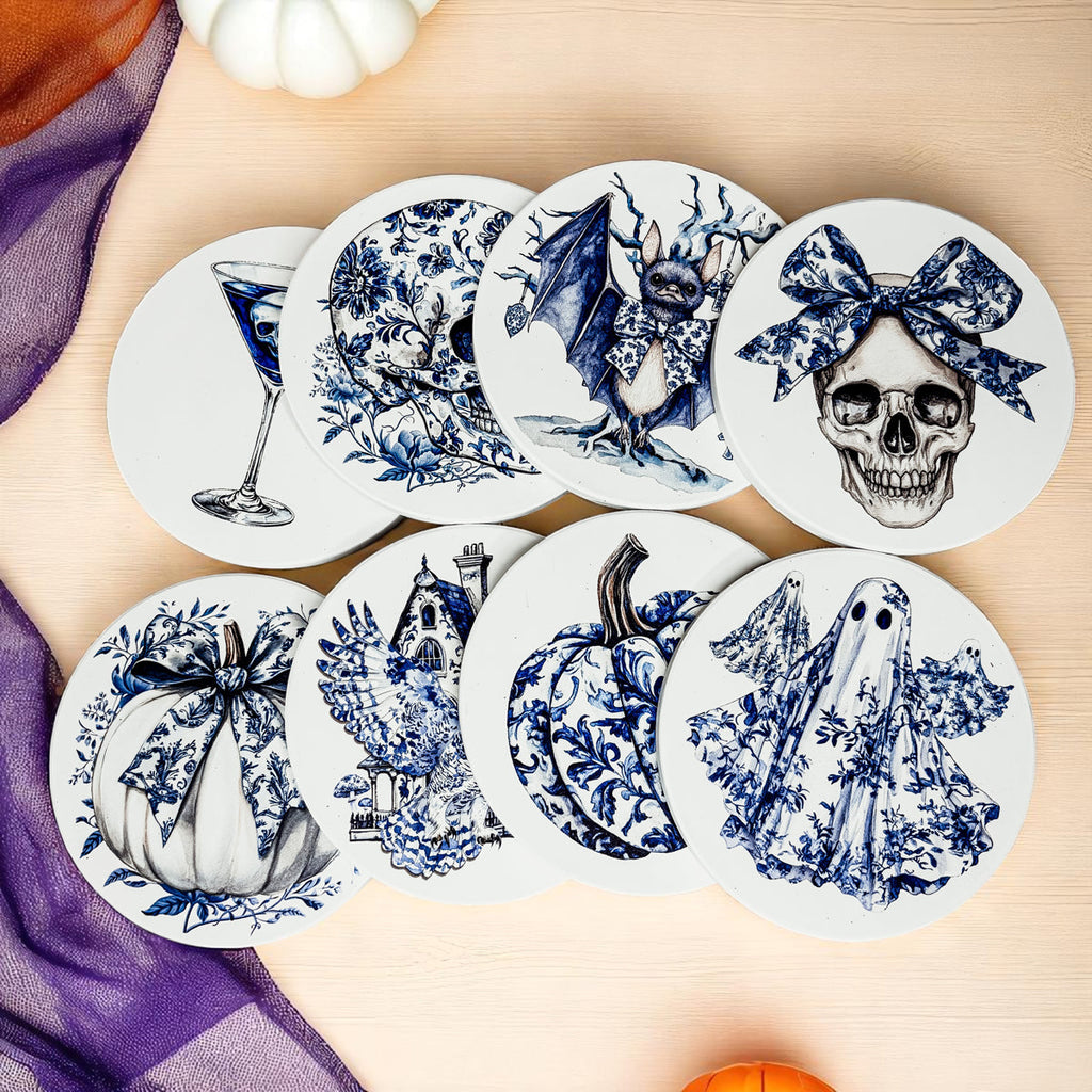Mixed blue-and-white Halloween coasters laid on a tabletop with skull, bat, and ghost designs