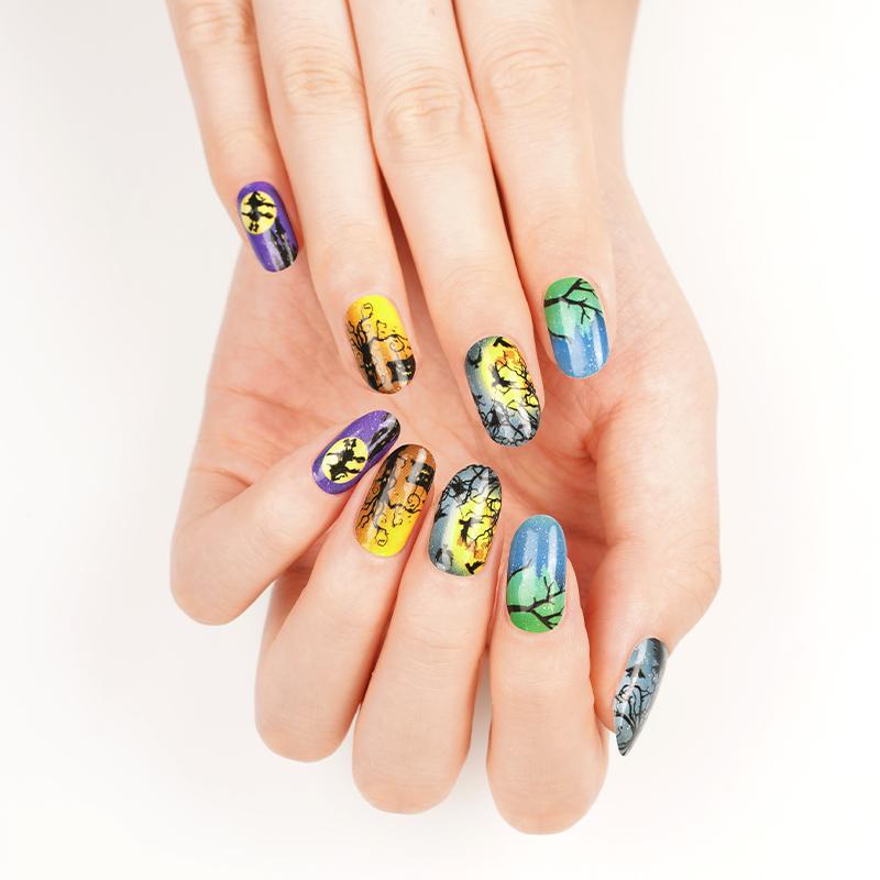 Halloween manicure on fingers with spooky black, yellow, blue, and purple nail art