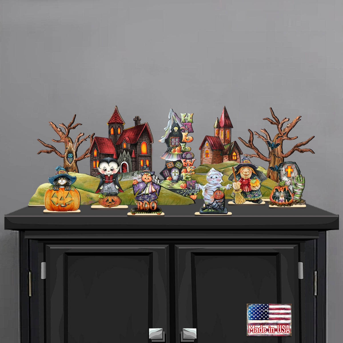 Halloween village figurine set with spooky house, pumpkins, and characters on black base.