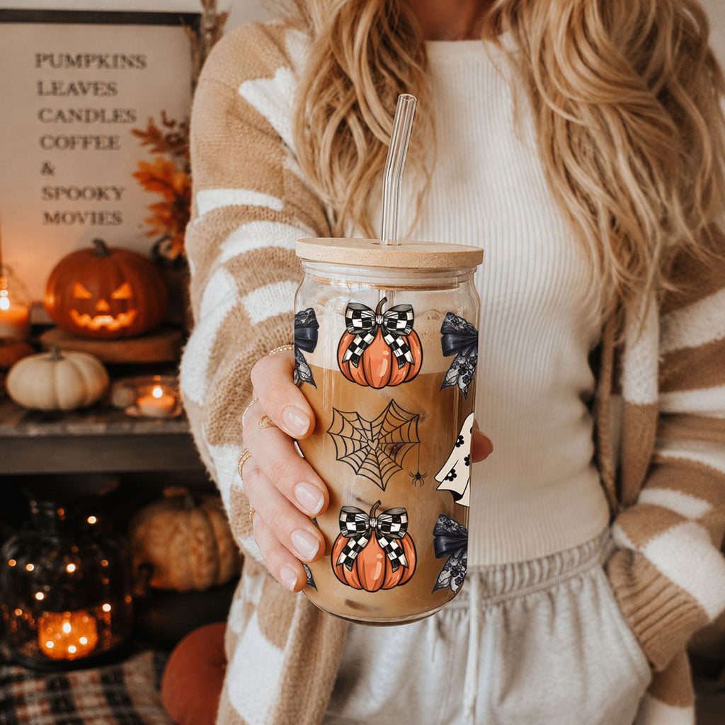 Hand holding a 20oz Halloween mason-style drink jar with straw and pumpkin bat patterned wrap